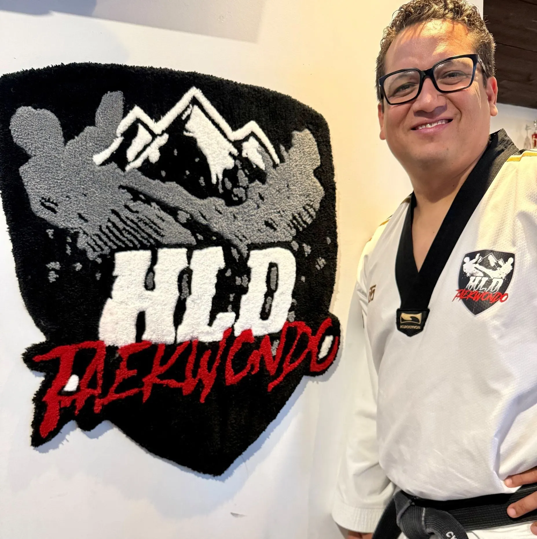 Tapis sur mesure au logo de HLD Taekwondo, avec le propriétaire de l’école