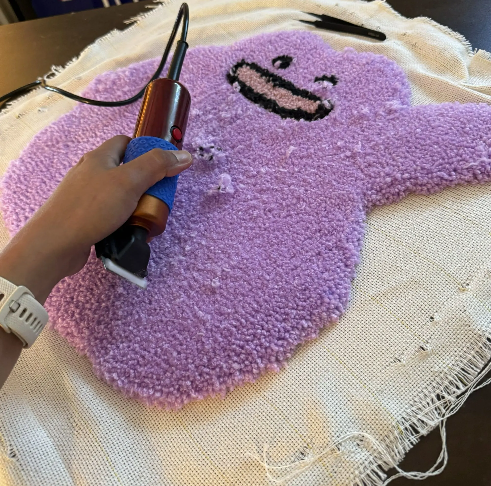 Rasage d’un tapis mauve pendant un atelier
