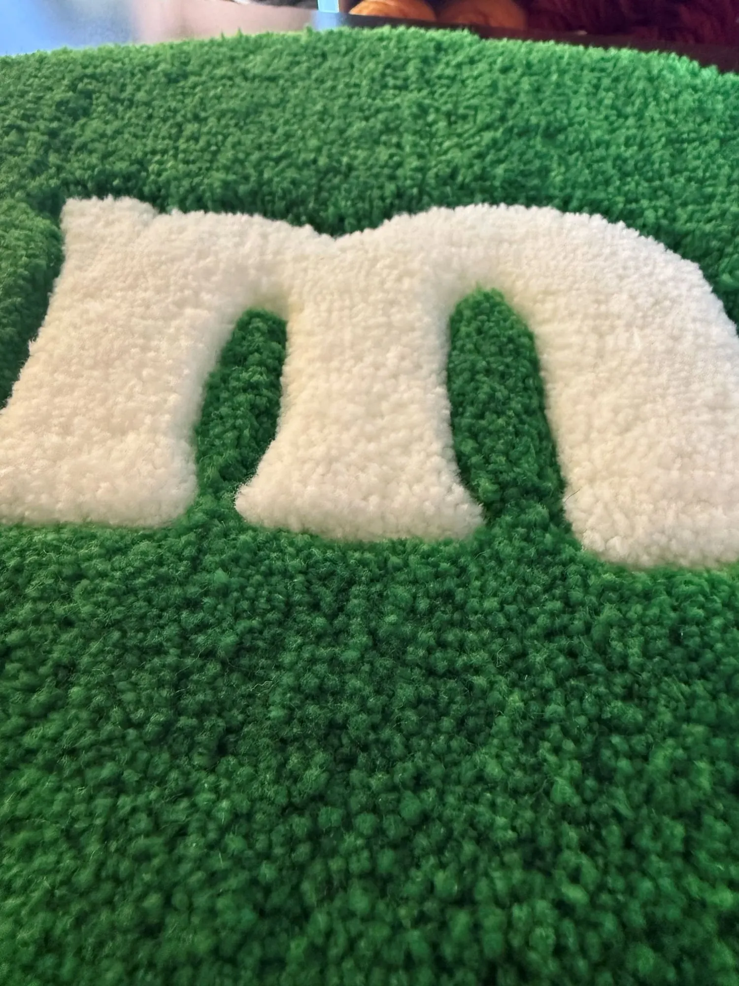 Tapis vert avec un « m » blanc